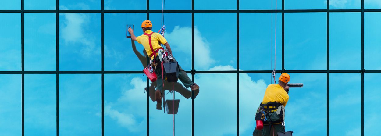 Window cleaning vendors working on a glass building